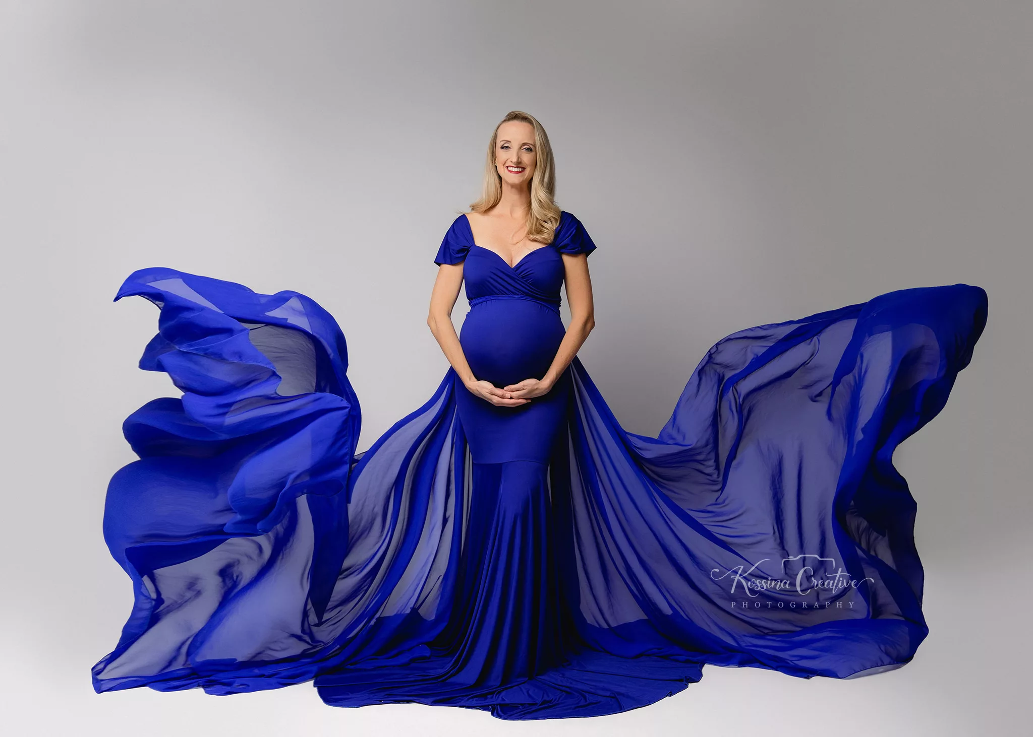 Orlando Maternity Photographer Photo Studio with flowy blue dress and grey background