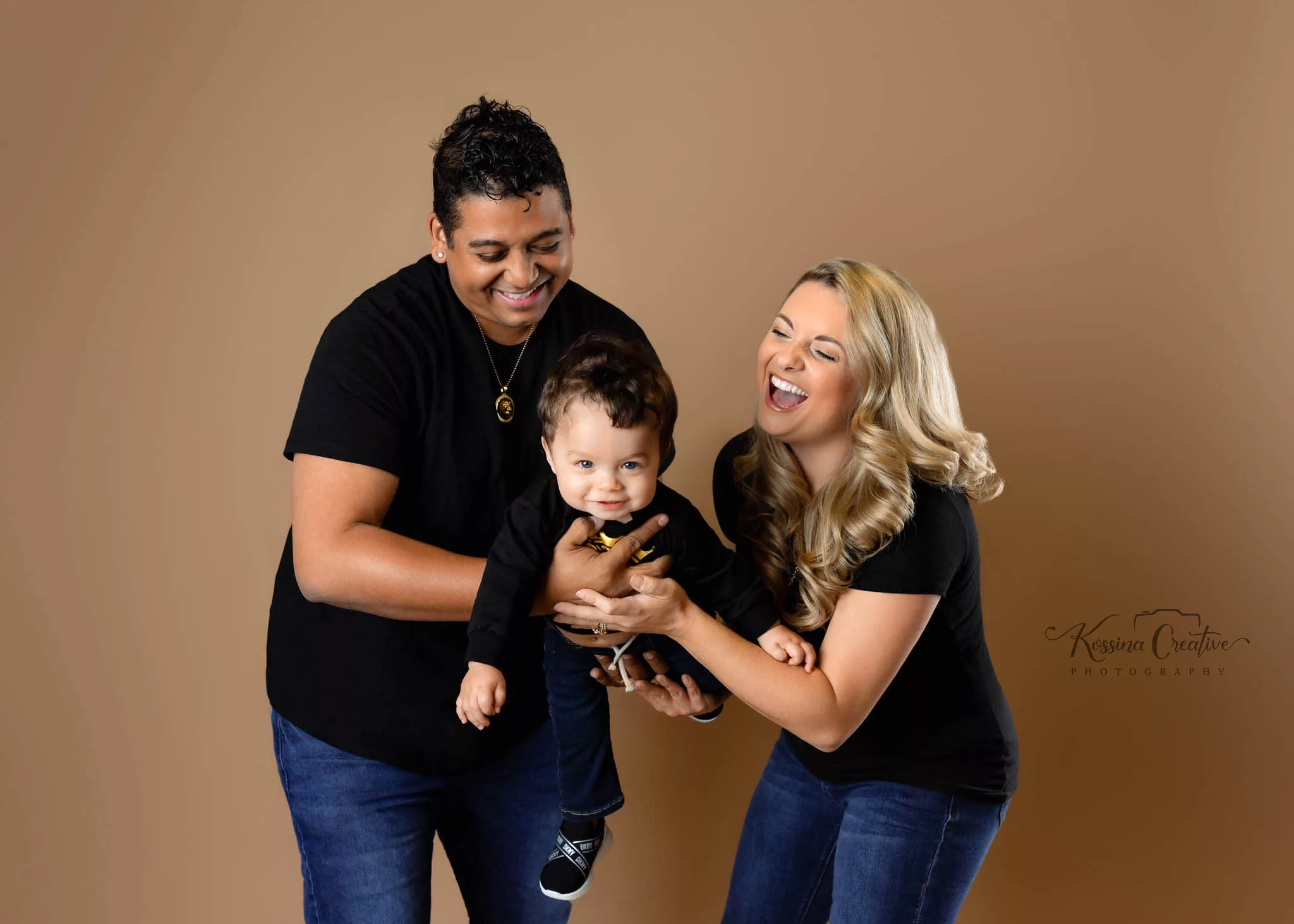 Orlando Family Cake Smash 1st Birthday Photographer Photo Studio brown background black tops and jeans swinging back