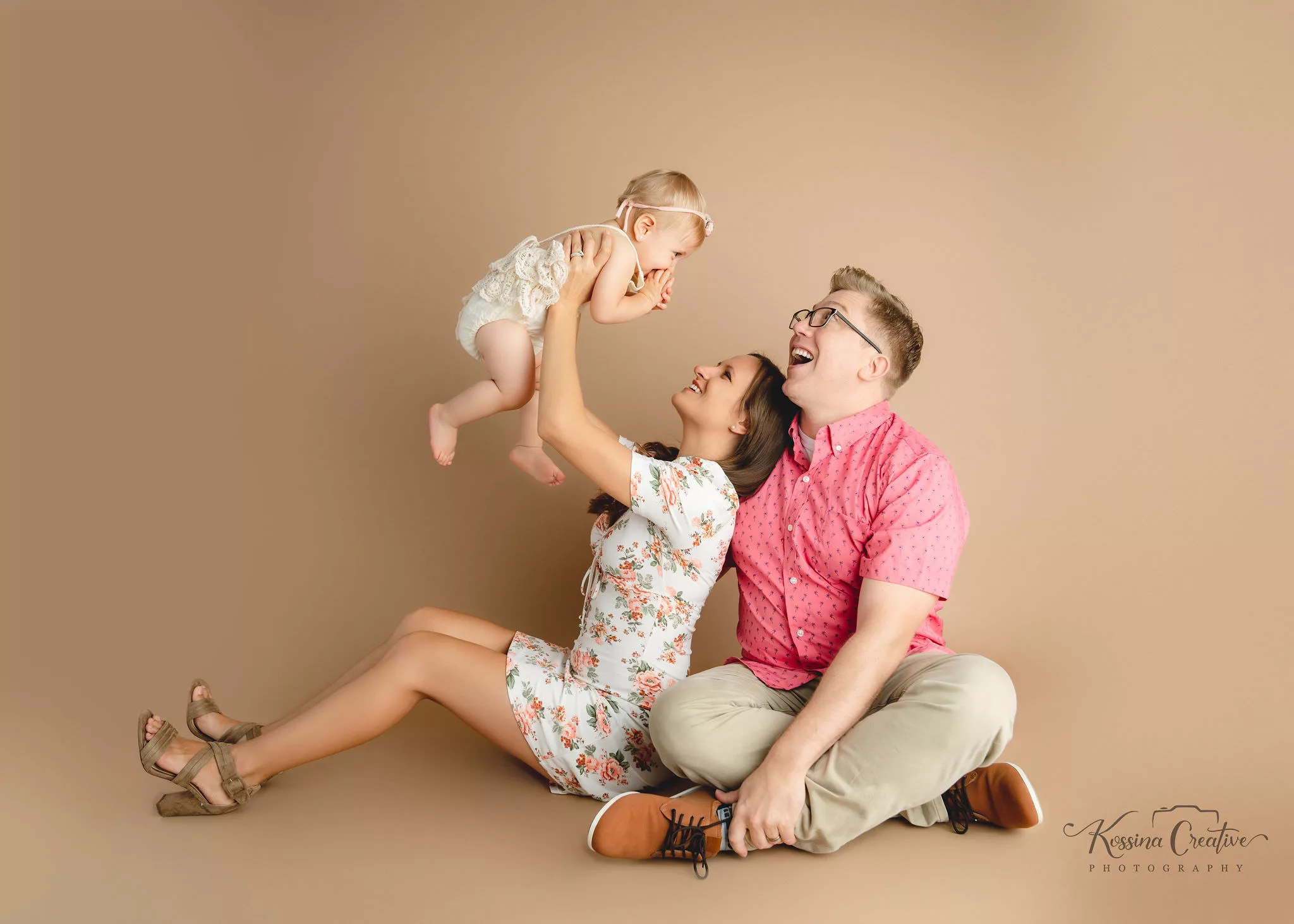 Orlando Family Cake Smash 1st Birthday Photographer Photo Studio brown background family of three baby up in air pink white