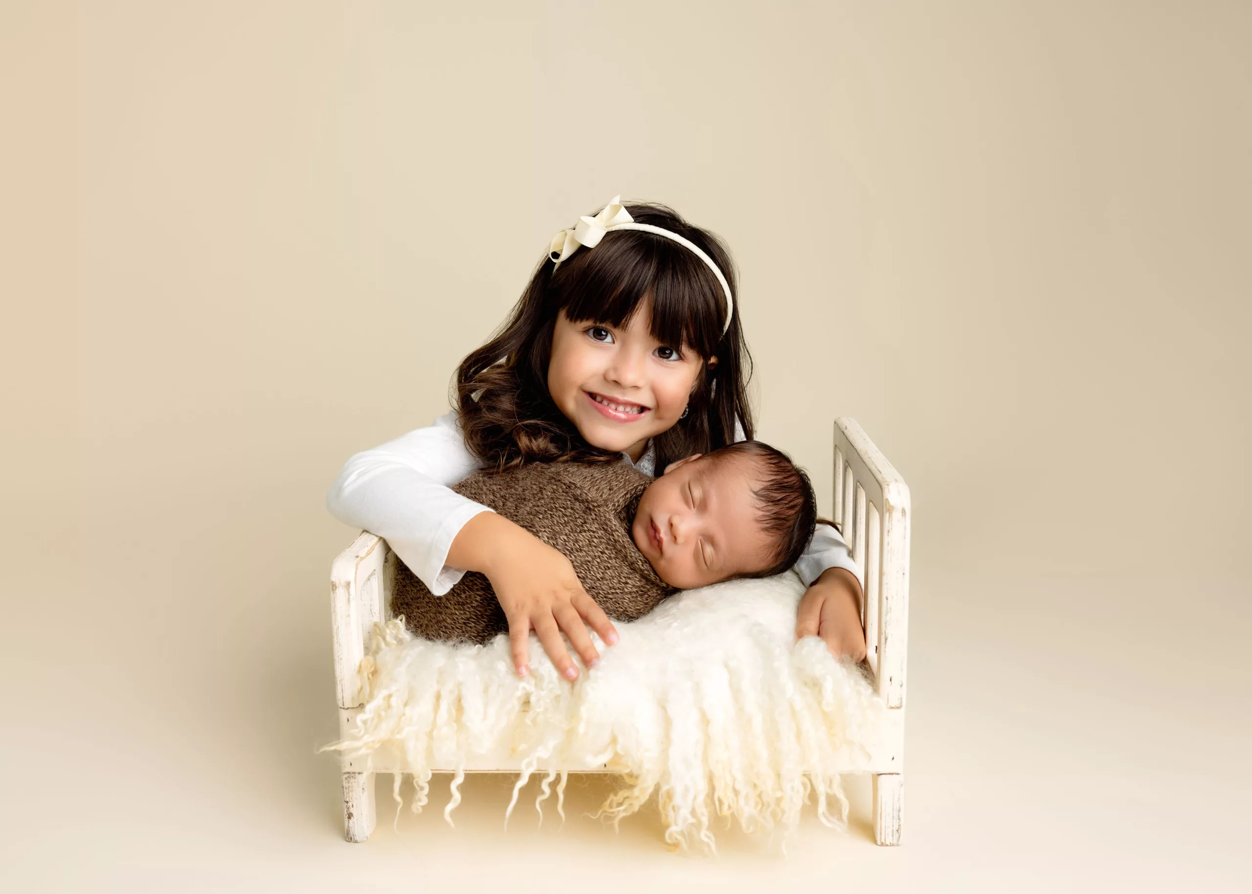 Orlando Family Newborn Photographer Baby Kid Photo studio siblings big sister baby brother cream bed hugging