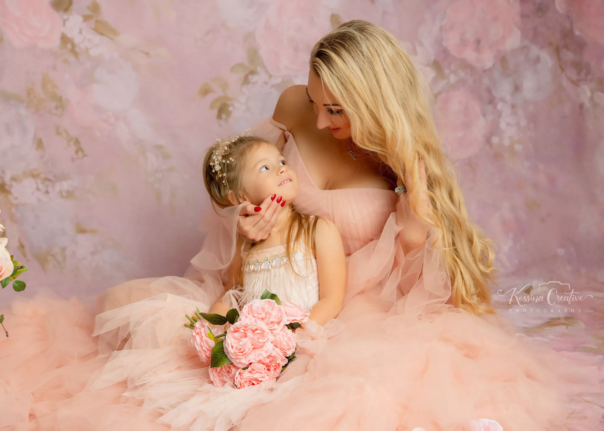 Orlando Family Photographer Motherhood Photo session mommy and me mini session mother and daughter laying down peach fluffy dress and floral backdrop