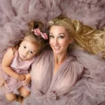 Orlando. Family Photographer Motherhood Photo session mommy and me mini session mother and daughter laying down with purple fluffy dress