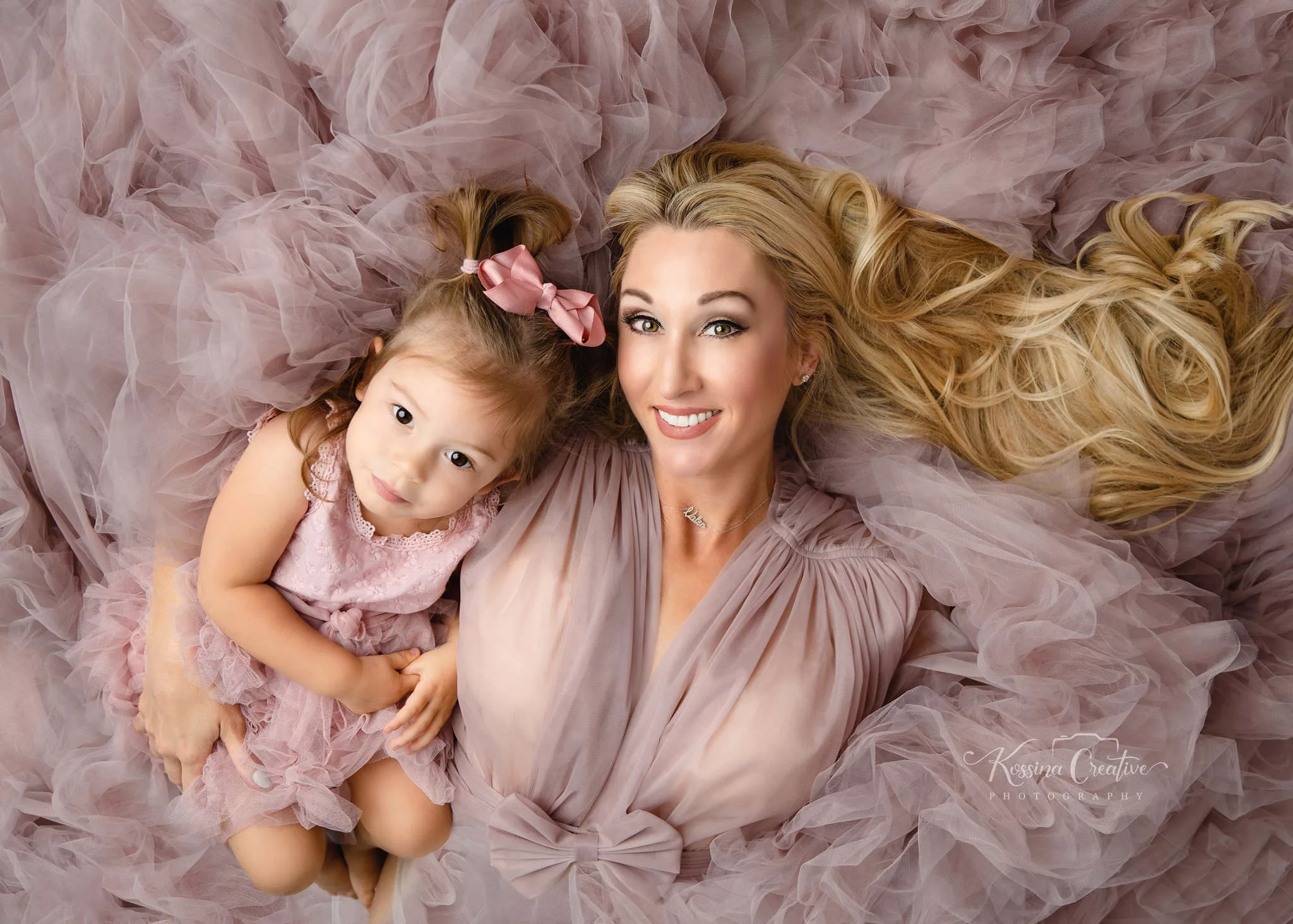 Orlando. Family Photographer Motherhood Photo session mommy and me mini session mother and daughter laying down with purple fluffy dress