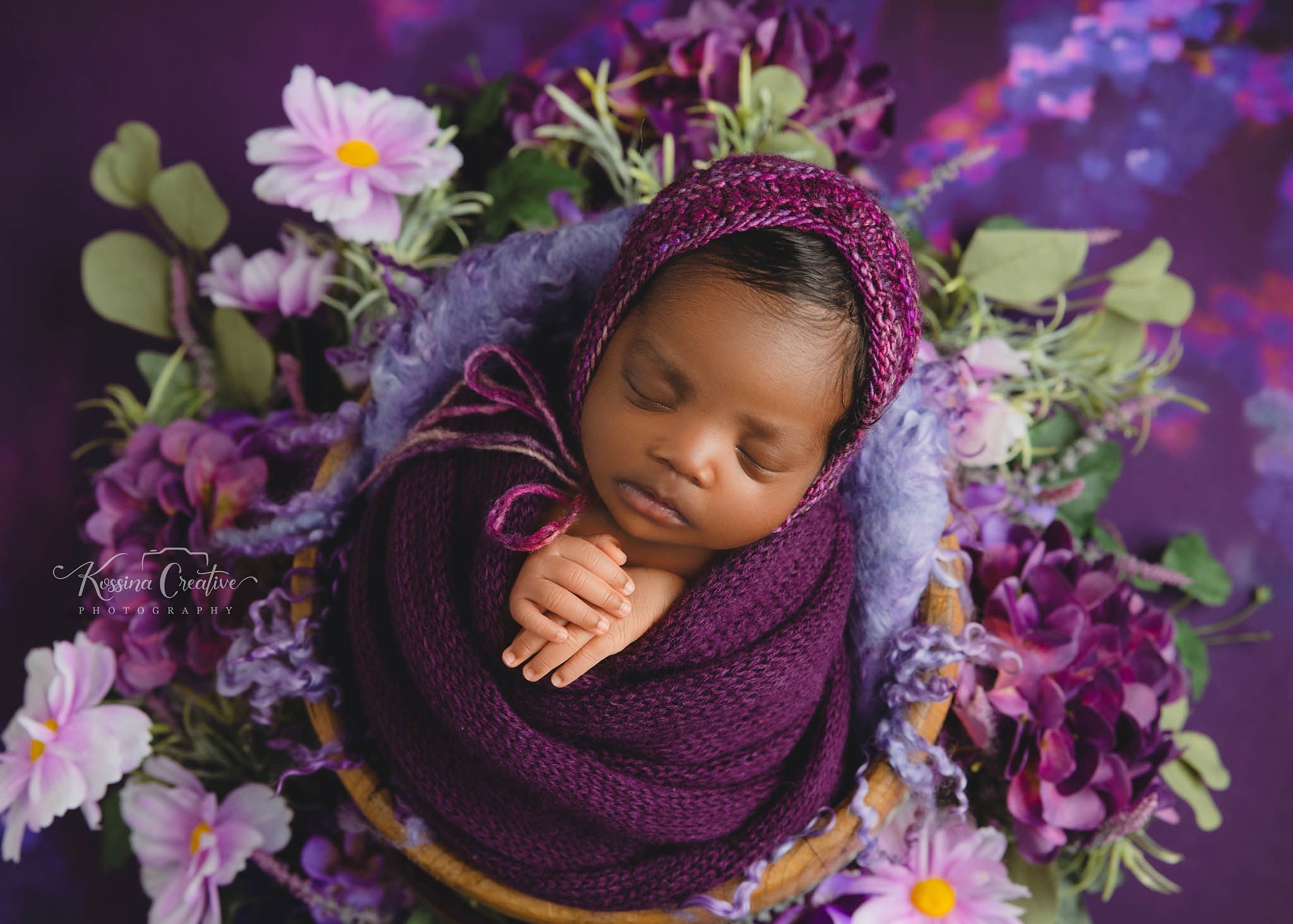 Newborn Photo with Purple Flowers and Purple Swaddle